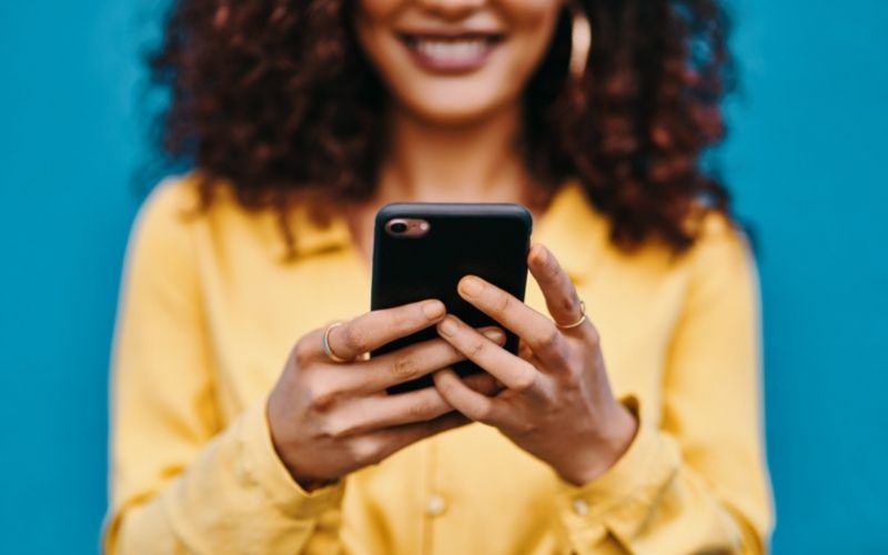 Woman on a smartphone symbolizing social media management.